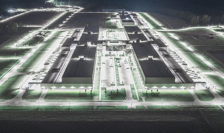 This image shows an aerial view of a Meta data center in Newton County, Georgia, illuminated at night.