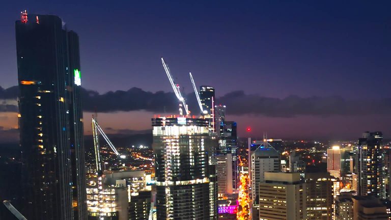 Aerial view Real time Footage of above Brisbane river over Kurilpa Bridge, Victoria Bridge and Captain Cook Bridge beside Modern Office Building at night time in Brisbane, Queensland, Australia, Business Financial Industry and Travel Destination Concept