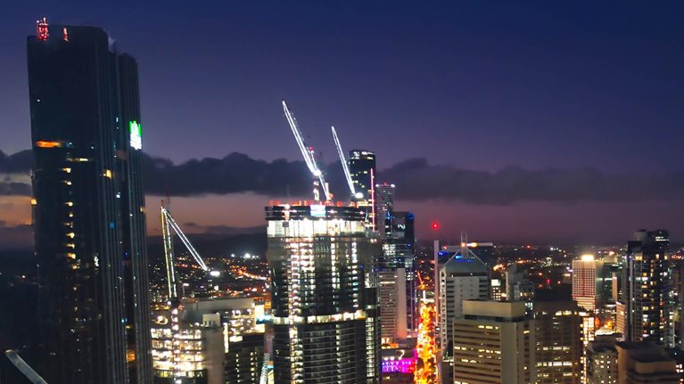 Aerial view Real time Footage of above Brisbane river over Kurilpa Bridge, Victoria Bridge and Captain Cook Bridge beside Modern Office Building at night time in Brisbane, Queensland, Australia, Business Financial Industry and Travel Destination Concept