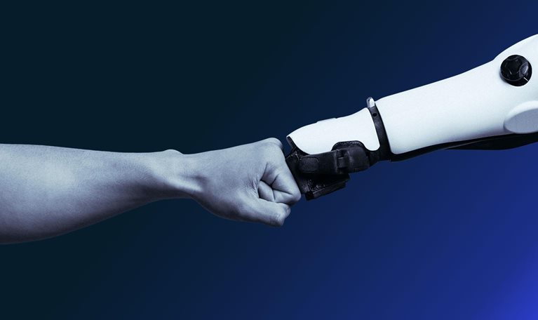 Human and robotic fists colliding.