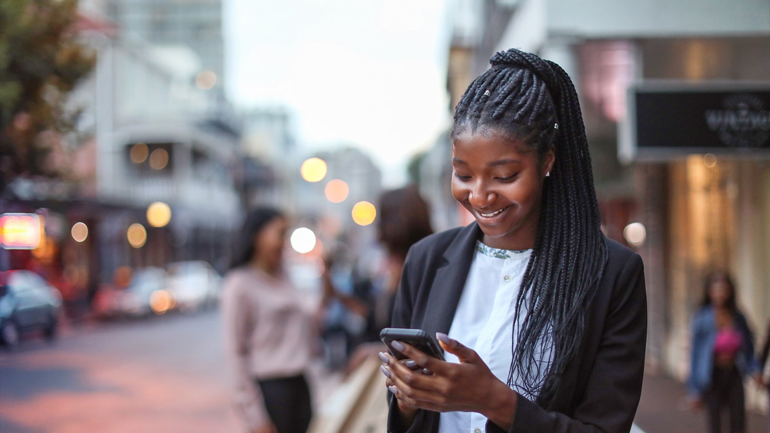 photo woman on street looking at mobile device