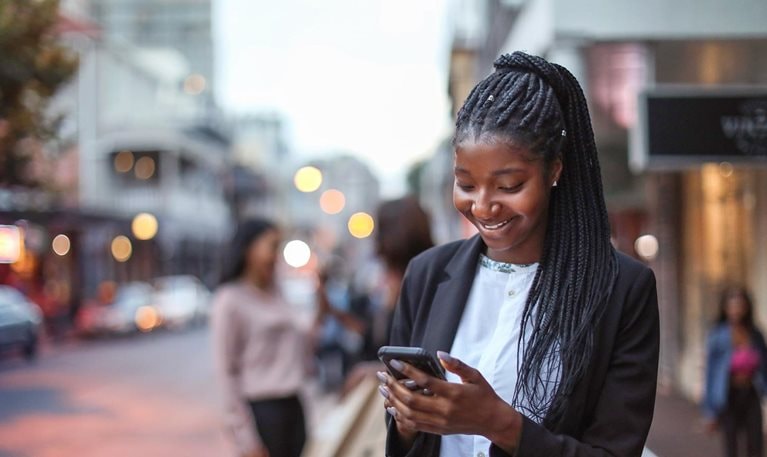 photo woman on street looking at mobile device