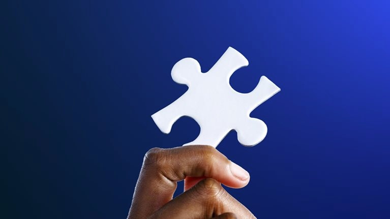 Hand holding a jigsaw puzzle
