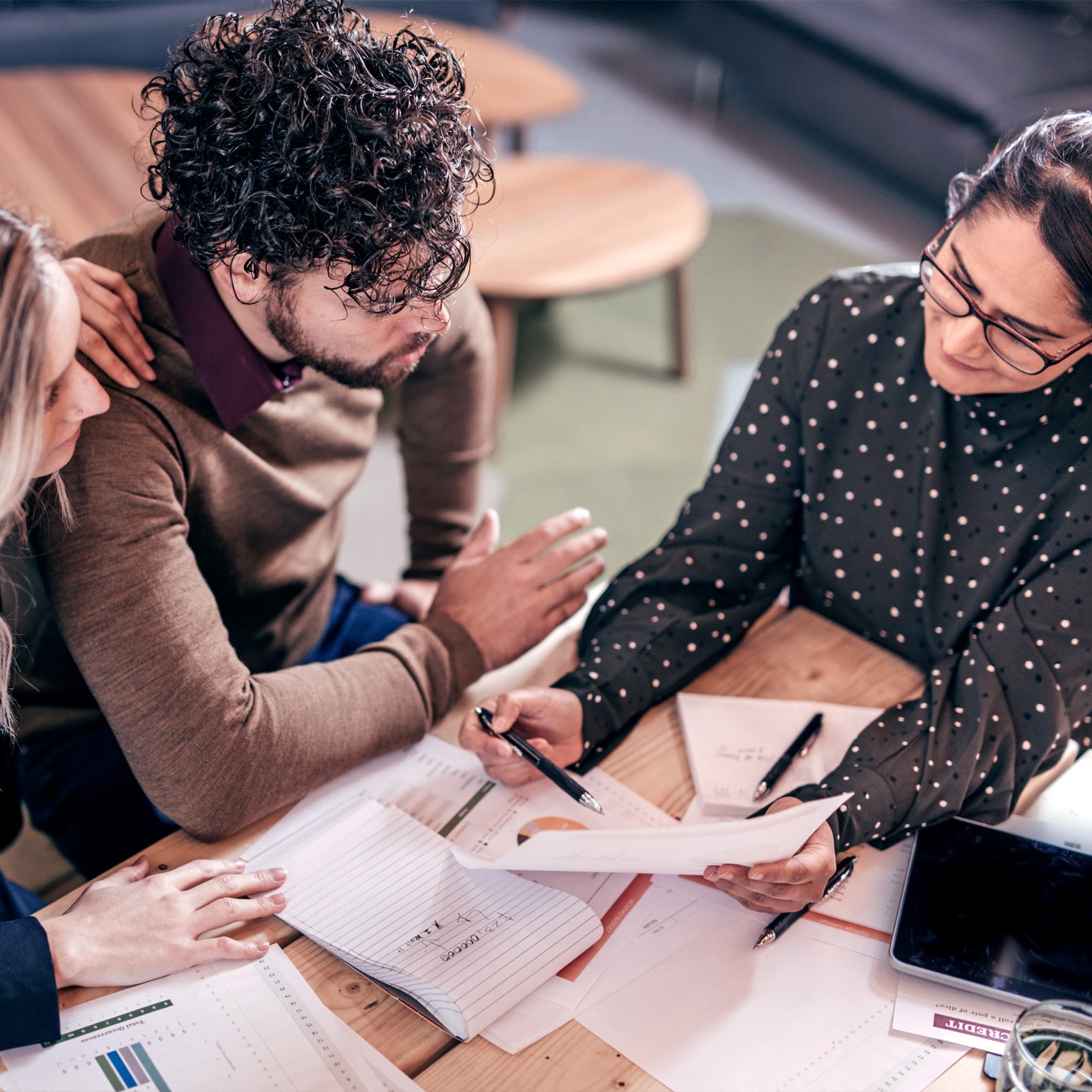 Overhead shot of couple sitting at table with female insurance agent