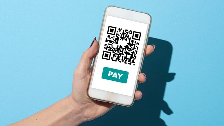 Woman with the QR code for payment on her smart phone