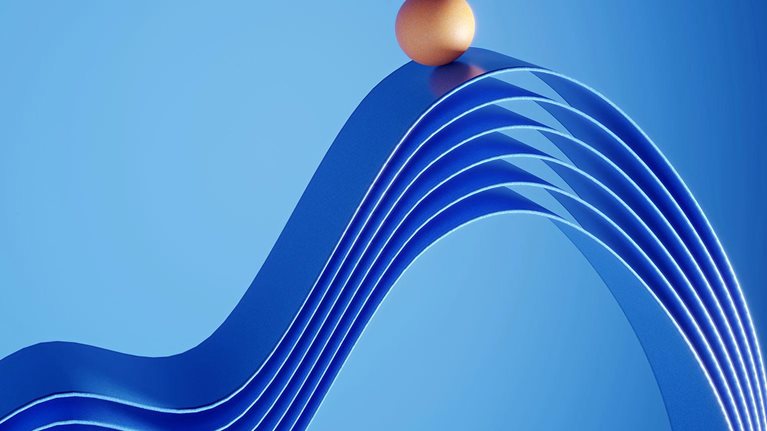 Orange colored ball standing on top of the ribbons