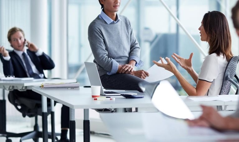 photo workers talking in small groups in conference room