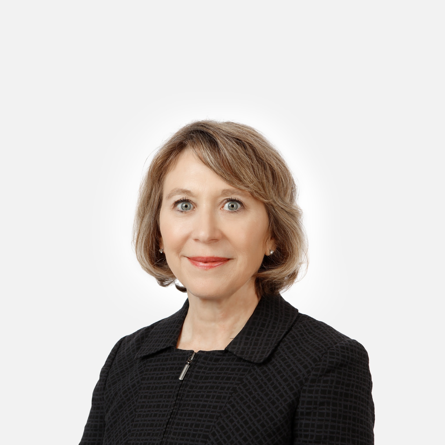 Portrait of a smiling Jayne Plunkett against a white backdrop.