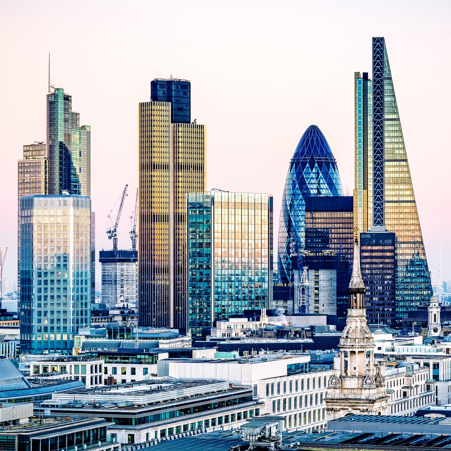 Sunset view of London's financial district, including The Gherkin and The Shard.