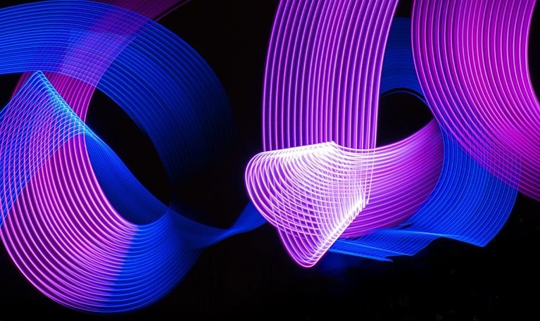 Conceptual blue and purple light lines painting swirling around and intersecting each other.