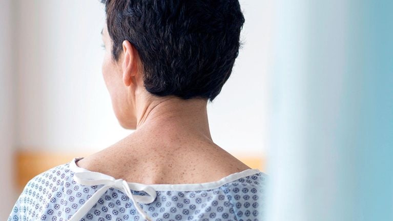 Rear view of senior woman wearing hospital gown