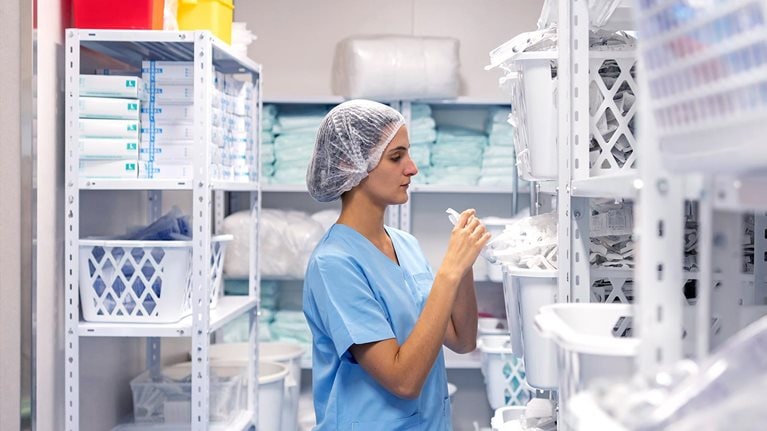 Nurse wearing face mask checking inventory at hospital