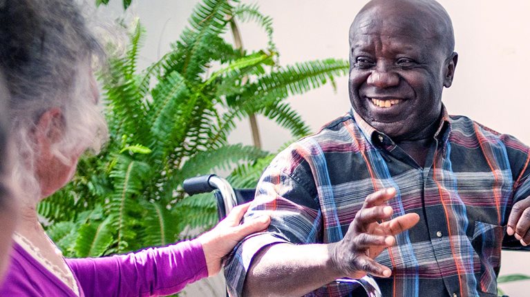 A group of diverse older people chatting with a counsellor during a therapy session in a residential care home