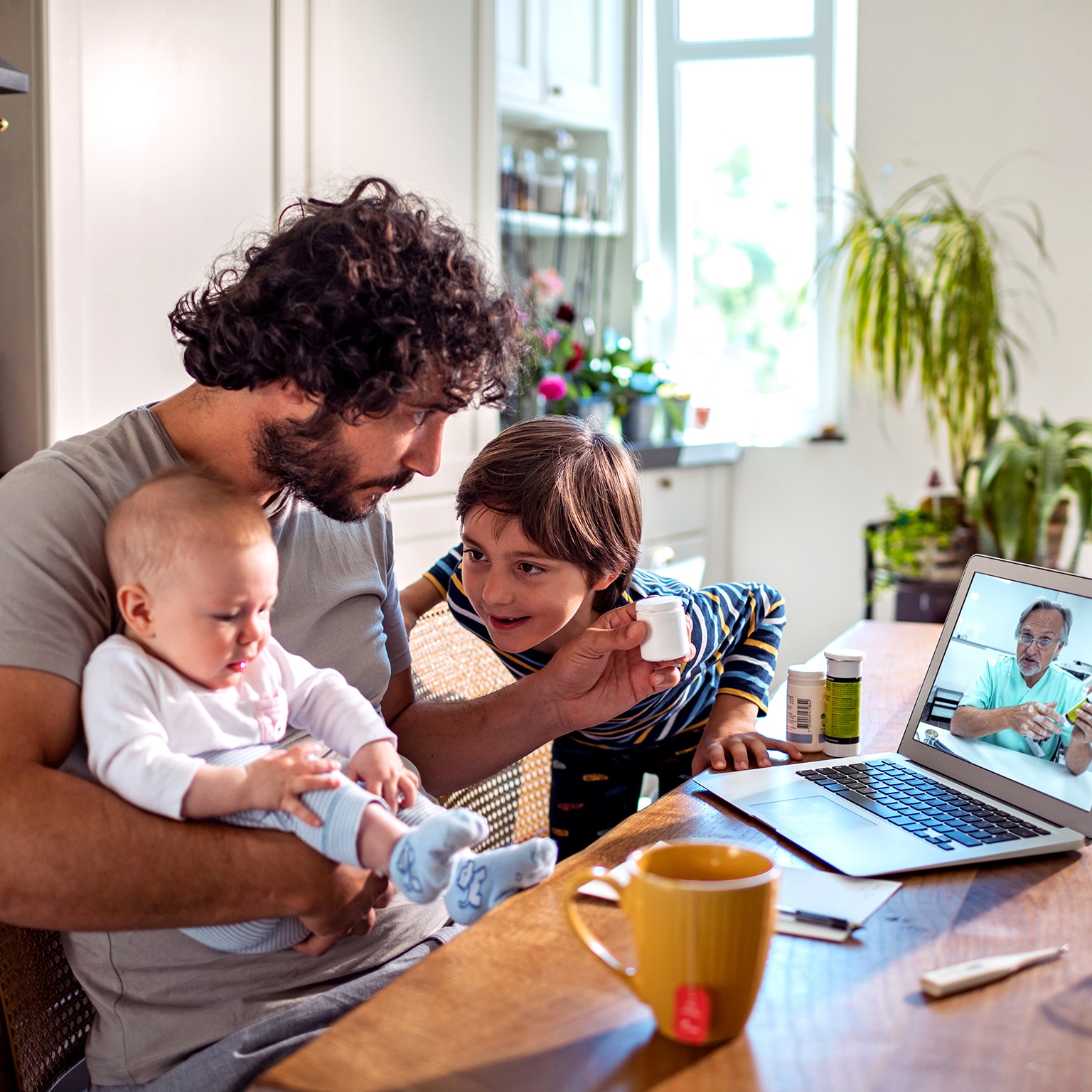 Father with two young children consulting doctor online