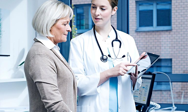 Doctor showing patient results on digital tablet