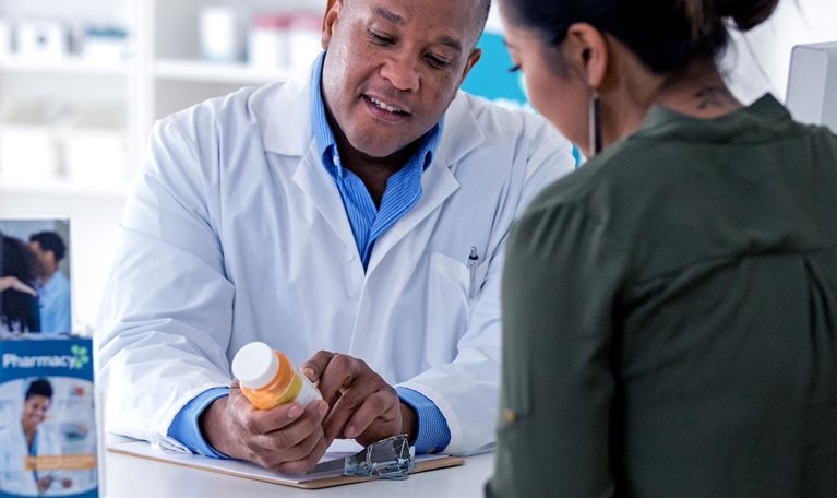 Pharmacist explaining to a customer across the pharmacy counter