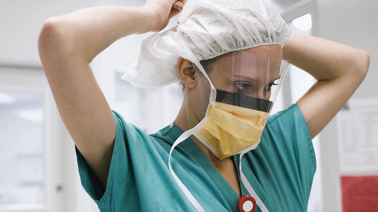 Surgeon tying surgical mask