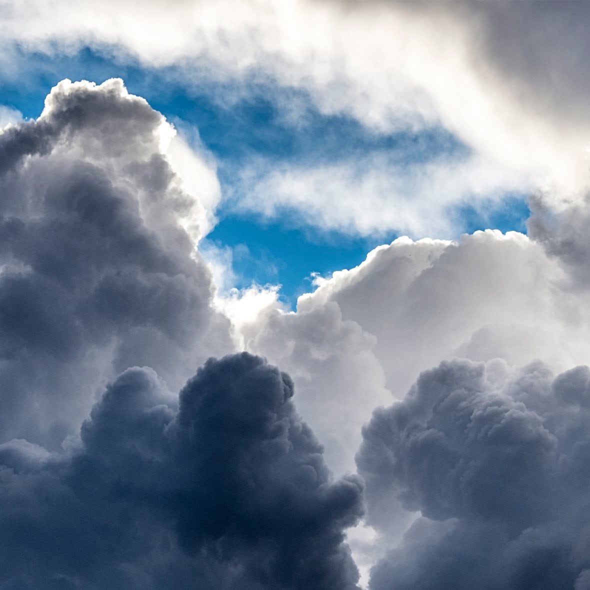 Sunny blue sky with large storm clouds in spring. - stock photo