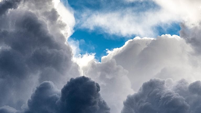 Sunny blue sky with large storm clouds in spring. - stock photo