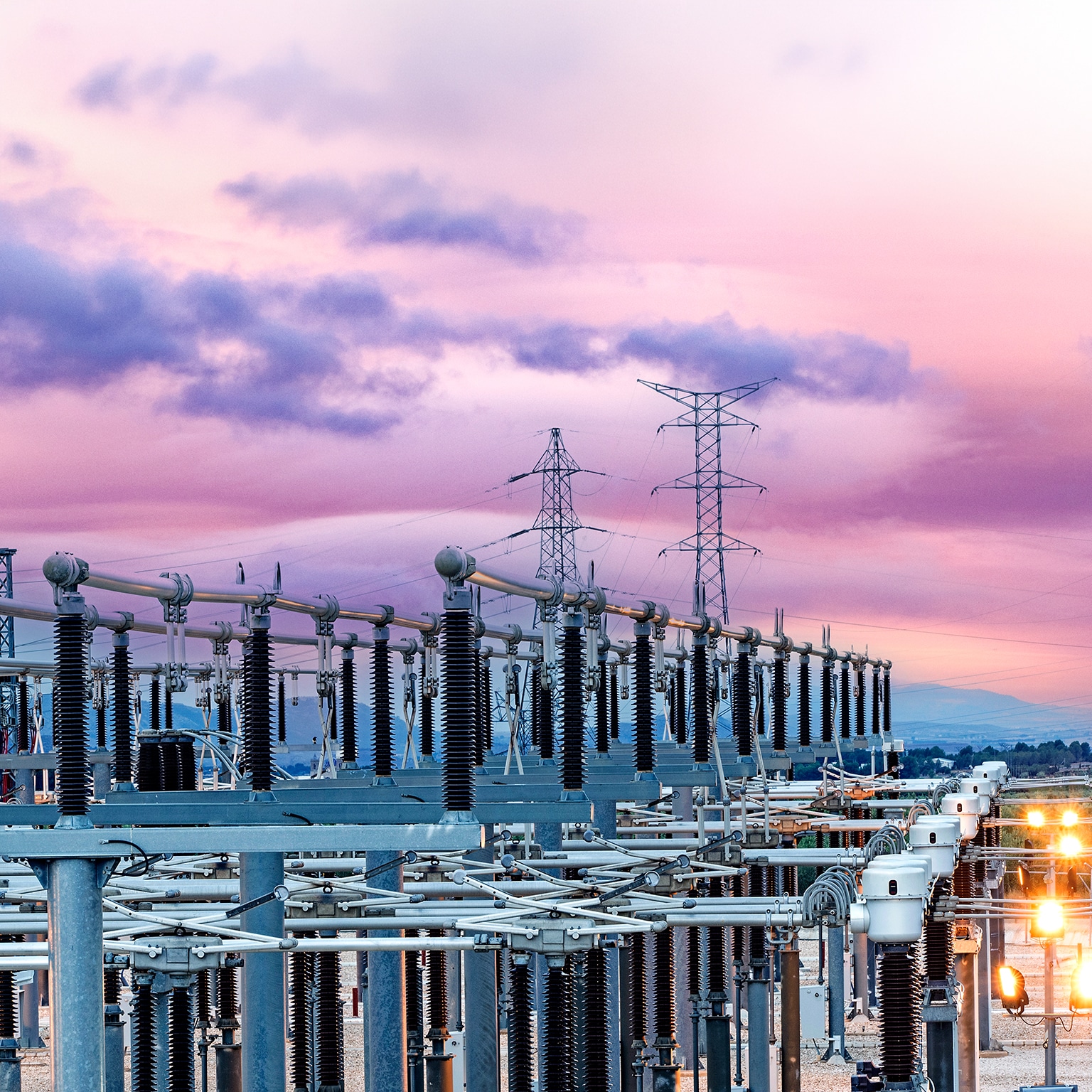 General view of an energy distribution power plant at dusk with the lights on