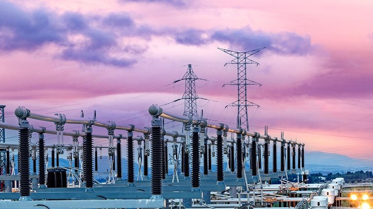 General view of an energy distribution power plant at dusk with the lights on