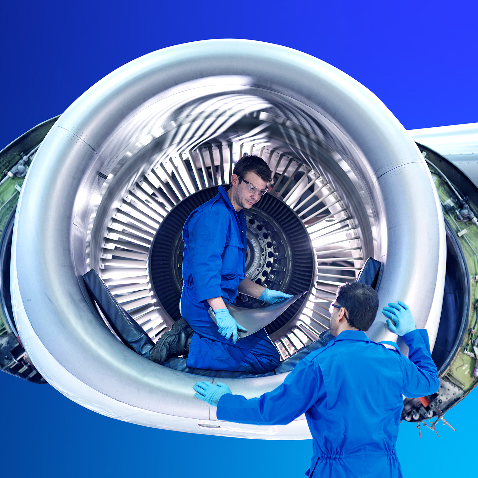 Engineers working with jet engine turbine blade in aircraft maintenance factory