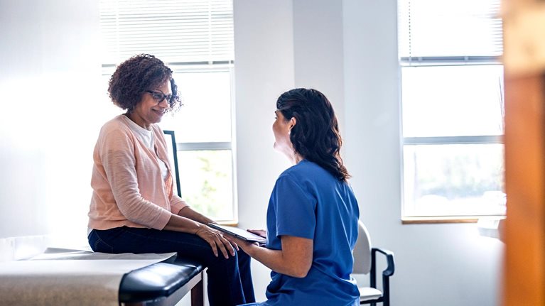 Doctor and senior woman discussing treatment in doctors office