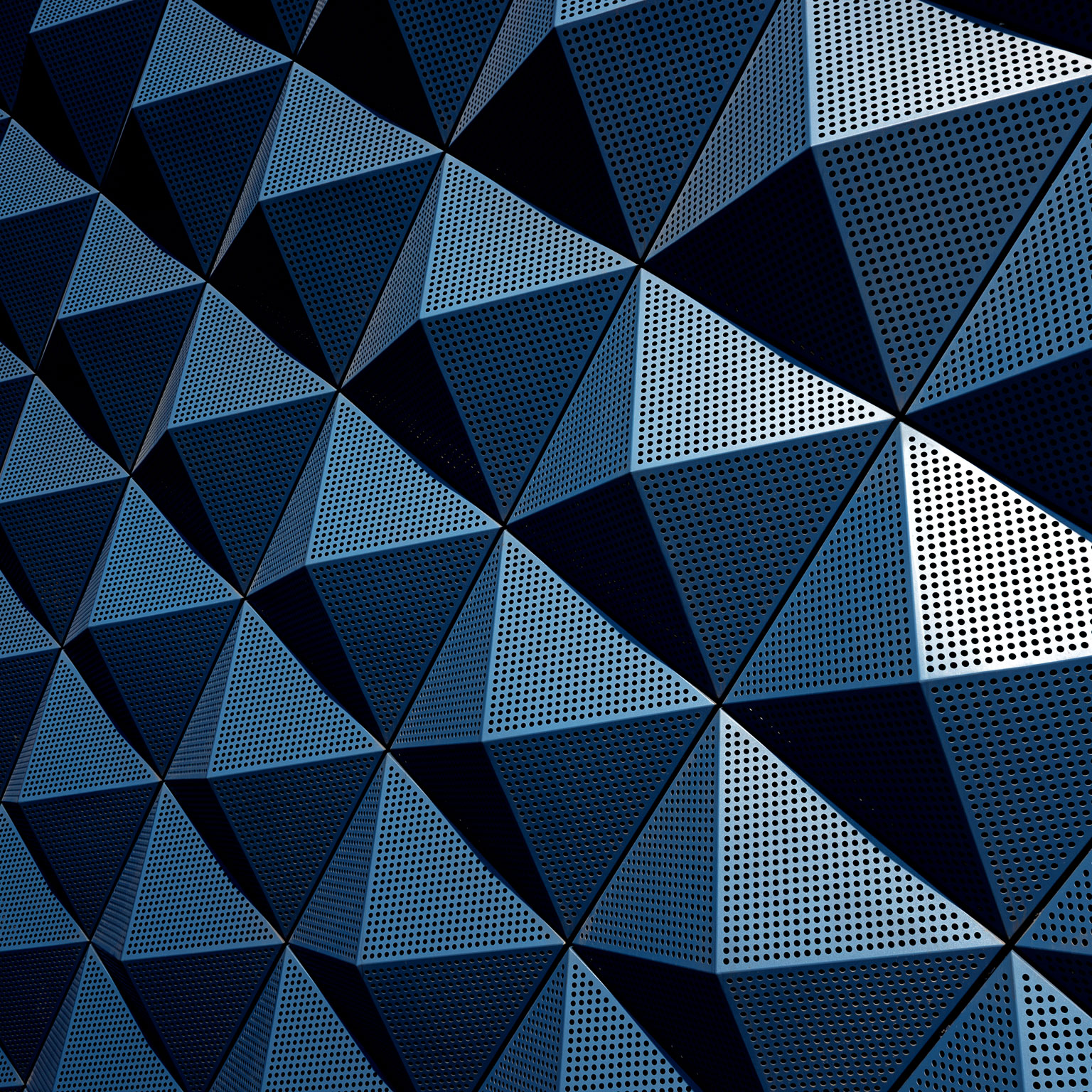 A wall composed of repeating metal pyramids