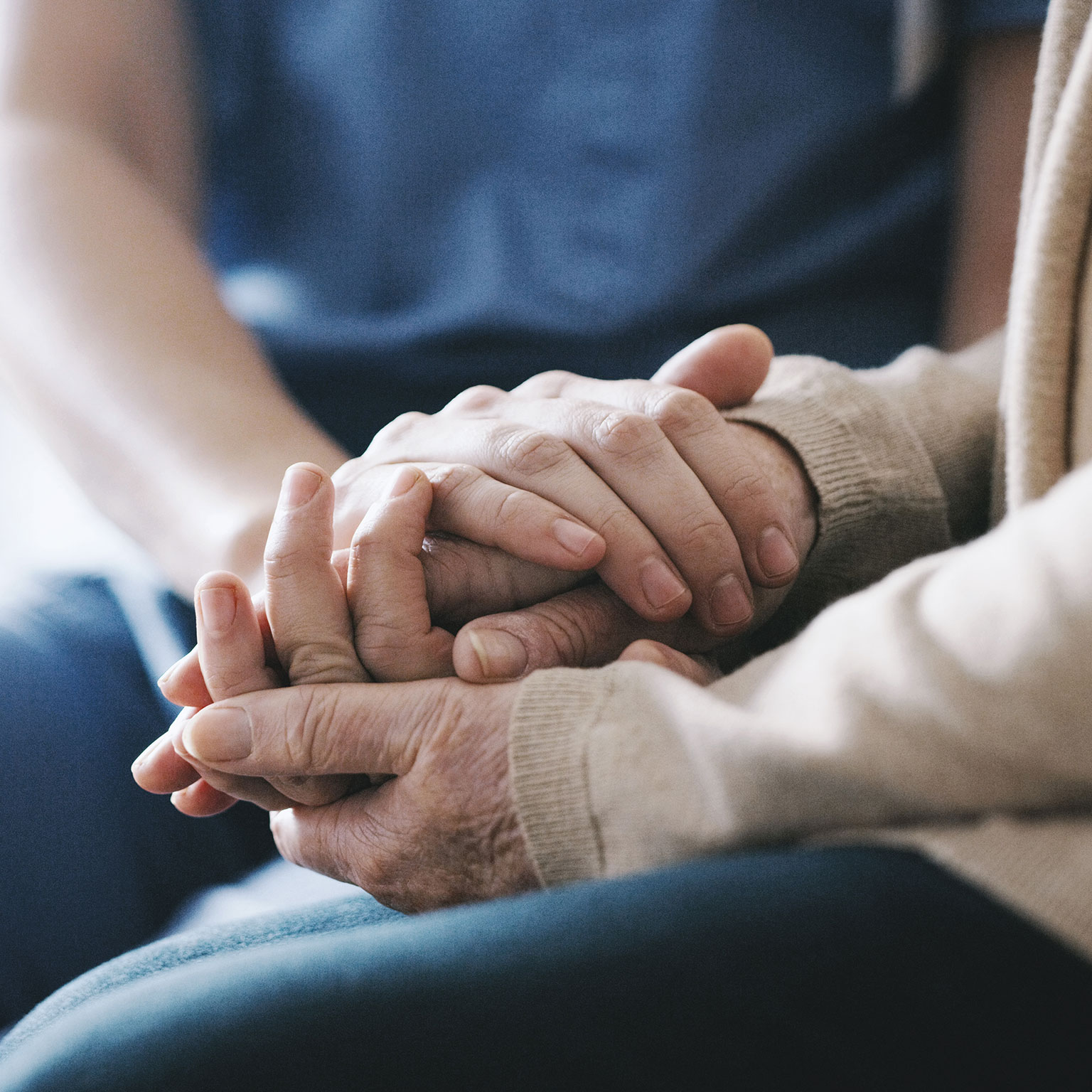 Cropped shot of a senior woman holding hands with a nurse