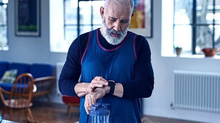 Senior man checking smart watch before exercising