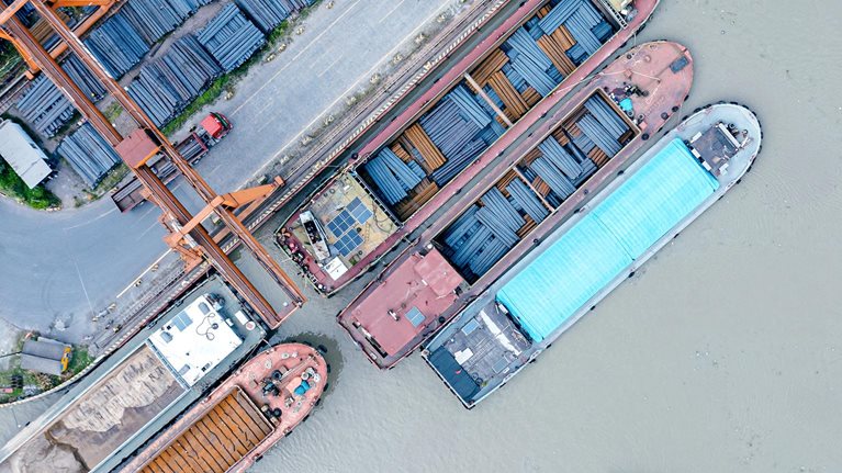 Aerial view of cargo ships docked at a steel terminal