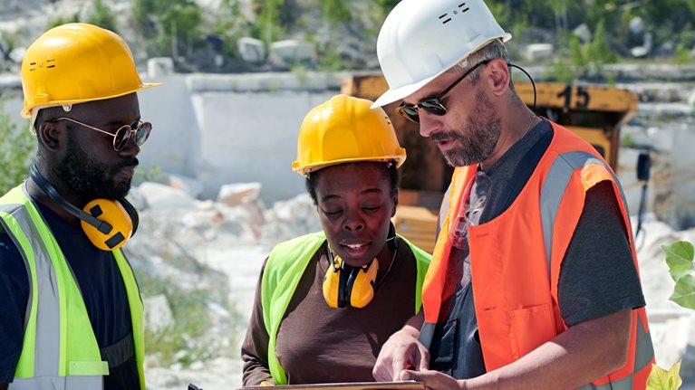 Mature man in workwear pointing at tablet screen during presentation