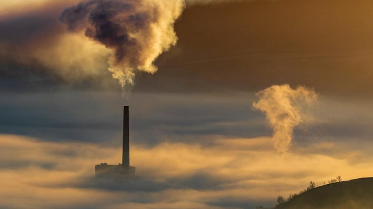 Hope valley and Castleton on a stunning misty morning with the pollution of the local cement factory at sunrise. Peak District National park. Derbyshire. - stock photo