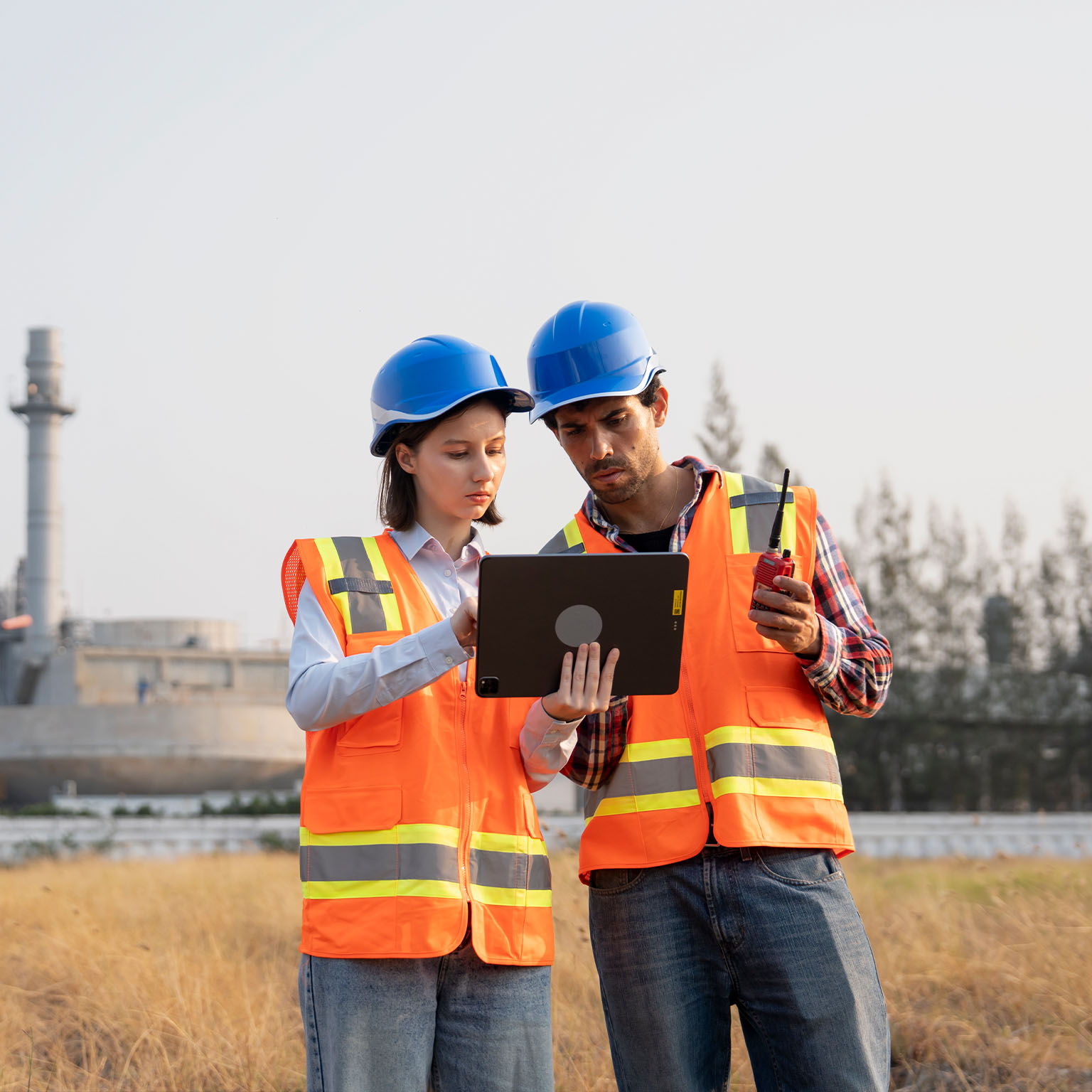 Male and Female Engineers working together in front of power plant factory