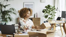Female business professional analyzing packaging while sitting at table