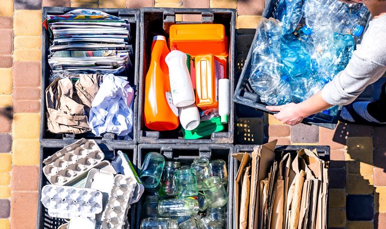 Woman organizes garbage containers for recycling