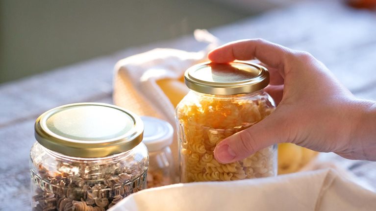 Woman standing indoors, unpacking zero waste shopping