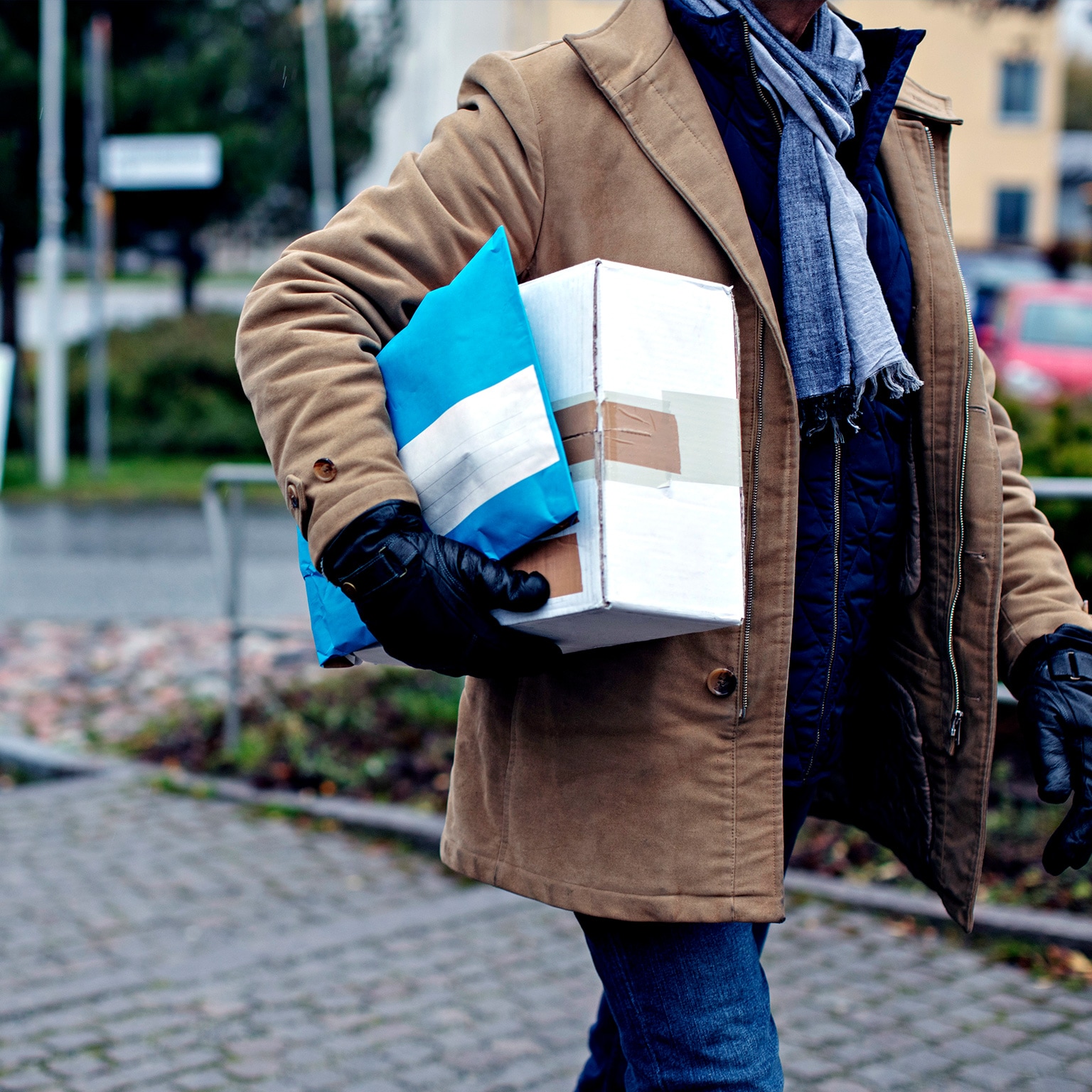Midsection of senior man with package walking by sidewalk during winter - stock photo