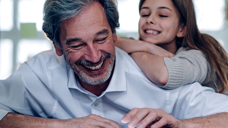 Happy senior businessman and girl looking at tablet in office.