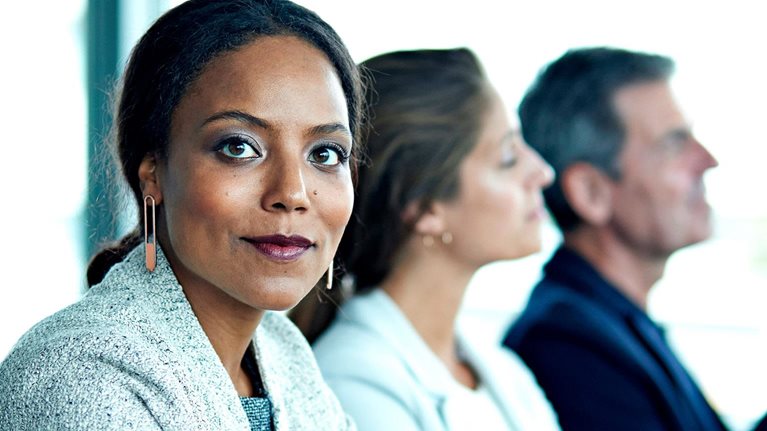 Female black corporate professional stares at camera