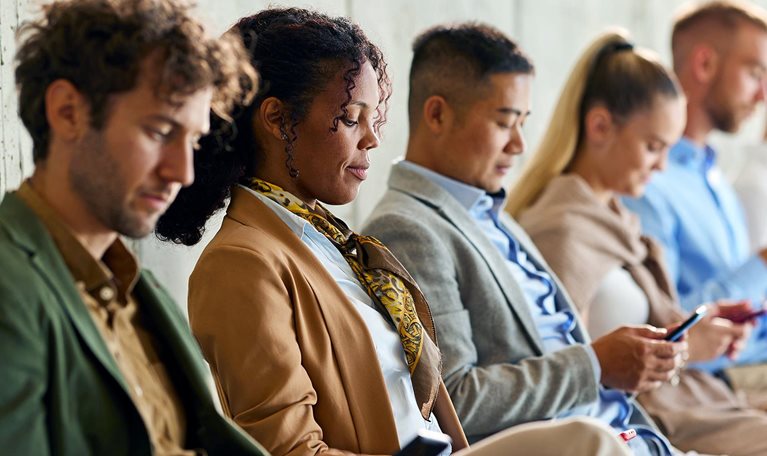 Large group of business people waiting for a job interview in a hallway.
