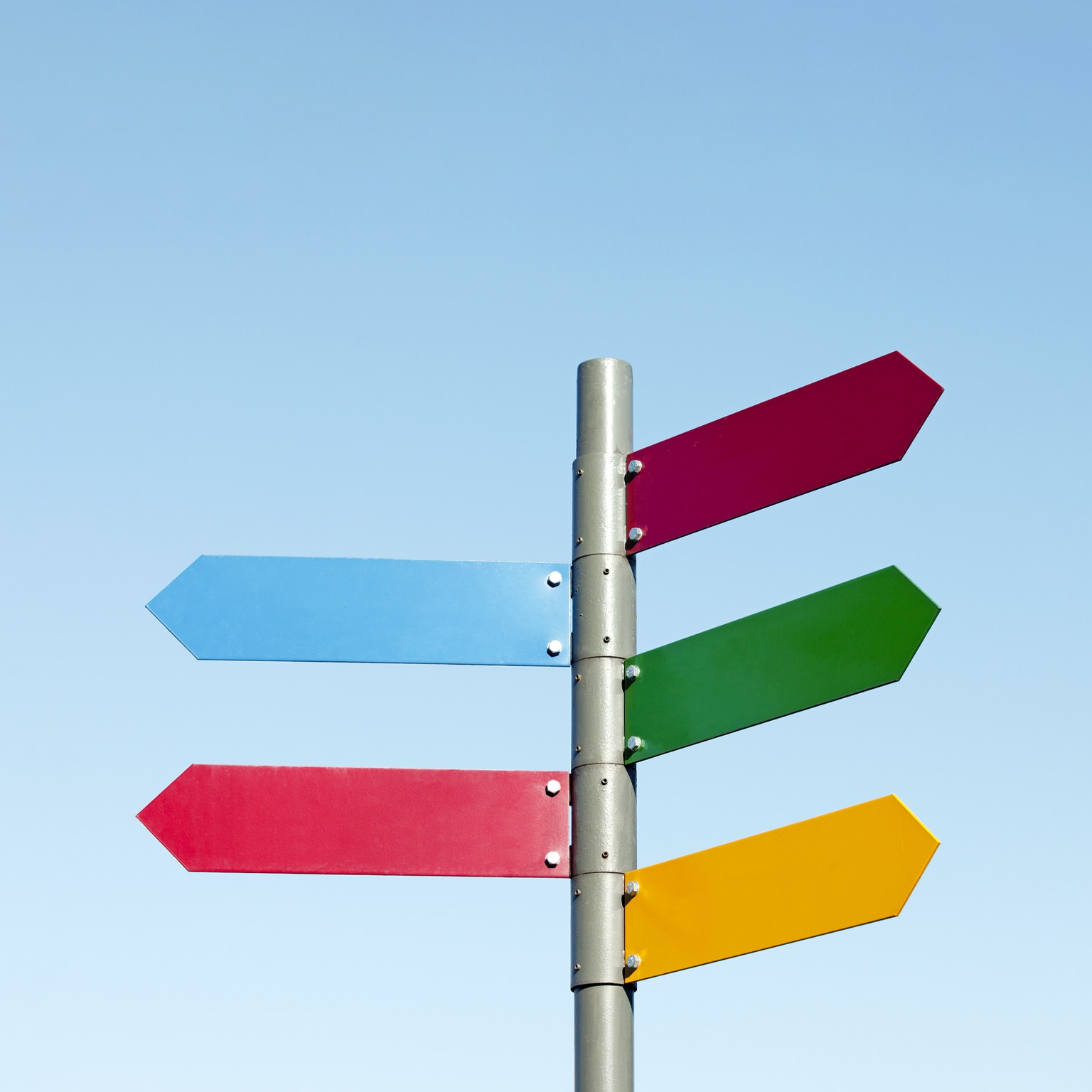 A signpost with arrow shaped signs of different colors pointing in different directions.
