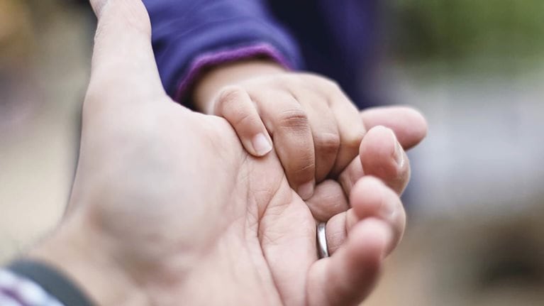 Child's hand holding adult's hand