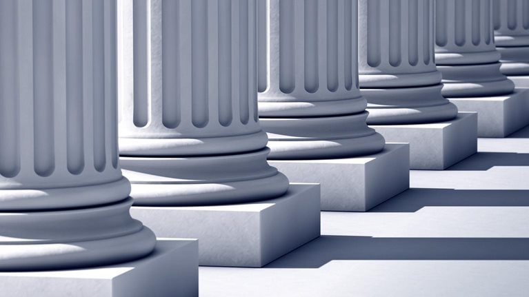 A deep row of stone columns casting long, linier shadows.