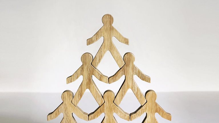 Wooden stick figures stacked in a pyramid.