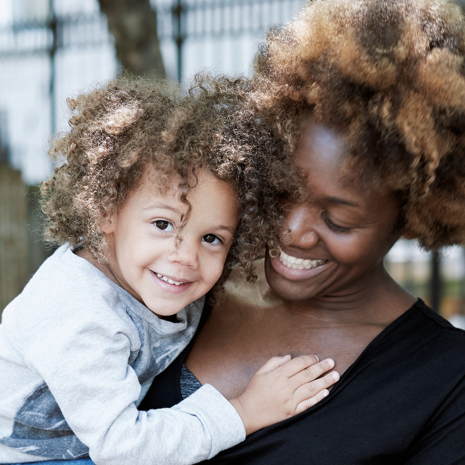 Smiling woman holding a happy child.