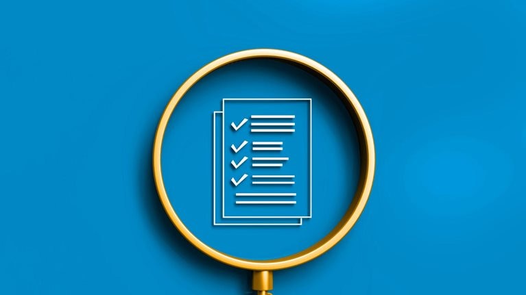 A gold magnifying glass with a checklist inside its lens, all against a solid blue background.