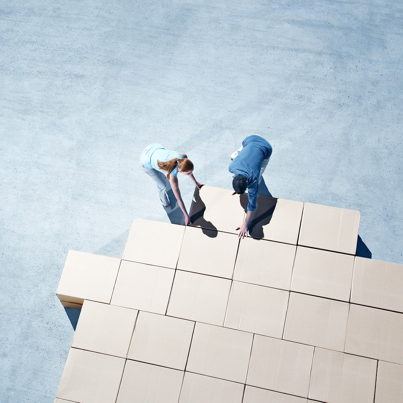 Couple building house outline on sidewalk - stock photo