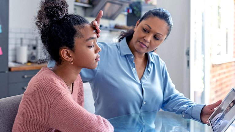 Lady doctor touching her patient's forehead