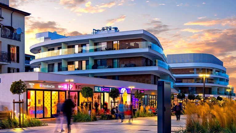Evening view of a promenade surrounded by mixed-use real estate